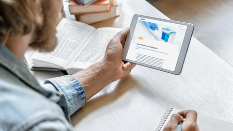 man taking notes while reading a KRÜSS article on a tablet man taking notes while reading a KRÜSS article on a tablet